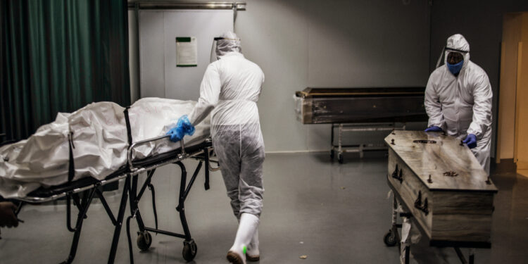 Undertakers move remains of COVID-19 coronavirus patients at the AVBOB funeral house in Soweto, on July 21, 2020. (Photo by MARCO LONGARI / AFP)