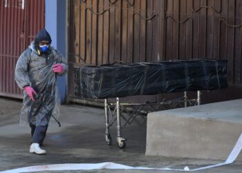 Empleados de una funeraria retiran el cuerpo sin vida de un hombre que permaneció durante horas abandonado en una calle, este domingo en Cochabamba (Bolivia). EFE/Jorge Ábrego