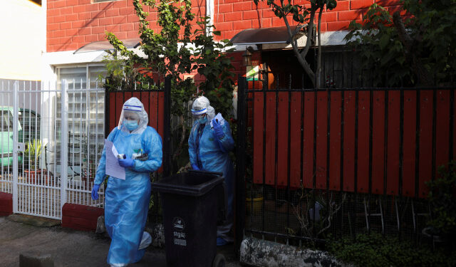 Foto de la médica venezolana Norelis Portal (D) y la técnica en enfermería chilena Blanca Pimente abandonando la casa de un paciente con coronavirus en Santiago. 
Jul 2, 2020. REUTERS/Pablo Sanhueza