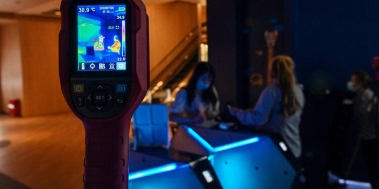 A camera shows body temperatures of customers at a cinema lobby during the first day of re-opening the theatres after COVID-19 in Shanghai on July 20, 2020. - Hundreds of cinemas reopened in scores of Chinese cities on July 20 following a nearly six-month nationwide shutdown due to the coronavirus. But the threat from COVID-19 remains in the air, with cinemas in Beijing still closed for now. (Photo by Hector RETAMAL / AFP)