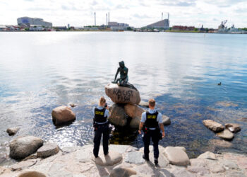 Copenhagen (Denmark), 03/07/2020.- Police officers take pictures of the iconic 'Little Mermaid' statue after the rock that serves as its plinth appeared with the message 'Racist Fish' in English spraypainted on it overnight in Copenhagen, Denmark, 03 July 2020. The bronze statue, created by sculptor Edvard Eriksen in 1913 based on the homonymous fairytale by Hans Christian Andersen, is one of the Danish capital's biggest tourist attractions. Over the past decades, it has been subjected to vandalism (decapitation, graffiti, defacement, etc.) numerous times. (Protestas, Abierto, Dinamarca, Copenhague) EFE/EPA/MADS CLAUS RASMUSSEN DENMARK OUT