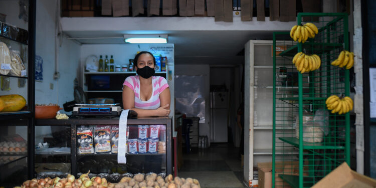An employee waits for customers at a photography store now selling food, due to the COVID-19 coronavirus pandemic, in Chacao neighborhood in Caracas on July 15, 2020, amid the coronavirus pandemic. - The COVID-19 pandemic, which reached Venezuela in mid-March and has infected some 10,000 people, according to official figures, forced the closure of 90% of the businesses in the Caribbean country, according to the private company Consecomercio. Only supermarkets, pharmacies and other businesses considered "essential" by the socialist government are exempted from the national quarantine, which has been tightened in Caracas due to the spread of the virus. (Photo by Federico PARRA / AFP)