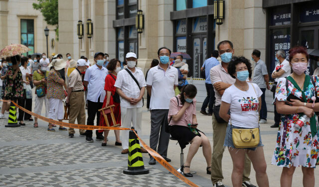 People line up to undergo COVID-19 coronavirus tests at a makeshift testing center in Dalian, in China's northeast Liaoning province on July 27, 2020. - China recorded 61 new coronavirus cases on July 27 -- the highest daily figure since April -- propelled by clusters in three separate regions that have sparked fears of a fresh wave. (Photo by STR / AFP) / China OUT