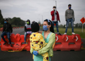 Migrantes venezolanos utilizando mascarillas participan en una protesta contra el bloqueo de los autobuses que contrataron para llegar a la frontera colombiana-venezolana, en medio del brote de la enfermedad por coronavirus (COVID-19) en Bogotá, Colombia, 29 de abril de 2020. REUTERS / Luisa Gonzalez