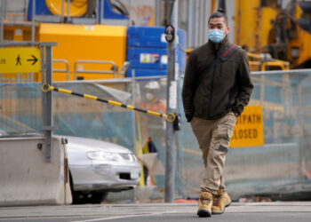 FOTO DE ARCHIVO: Un hombre con una mascarilla por una calle de Melbourne, el 23 de julio de 2020. REUTERS/Sandra Sanders