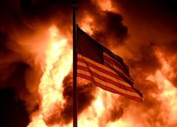 IMAGEN DE ARCHIVO. LLamas envuelven el edificio de la División de Correcciones Comunitarias mientras ondea una bandera estadounidense en un poste, tras manifestaciones provocadas por los disparos de un policía a un hombre negro en Kenosha, Wisconsin, EEUU, Agosto 24, 2020. REUTERS/Stephen Maturen