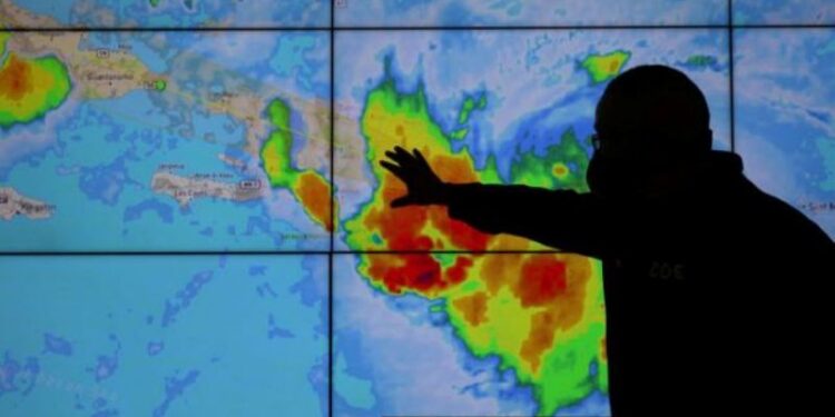 Un miembro del Comité de Operaciones de Emergencia mira la trayectoria de la tormenta Laura en Santo Domingo, República Dominicana. 22 agosto 2020. REUTERS/Ricardo Rojas