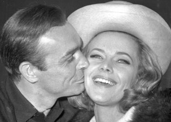 En esta foto de archivo del 25 de marzo de 1964, el actor británico Sean Connery besa a la actriz Honor Blackman durante una fiesta en los Estudios de Cine Pinewood, en Iver Heath, Inglaterra.