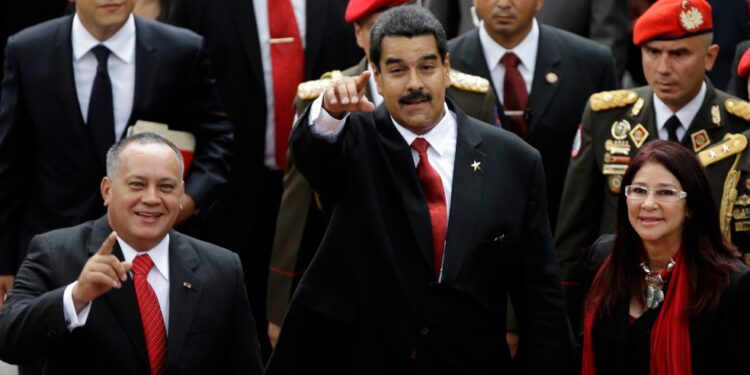 National Assembly President Diosdado Cabello, left, Venezuela's President-elect Nicolas Maduro, center, and his companion Cilia Flores greet supporters upon their  arrival to the Venezuelan Parliament for his inauguration in Caracas, Venezuela, Friday, April 19, 2013. The opposition boycotted the swearing-in, hoping that the ruling party's last-minute decision to allow an audit of nearly half the vote could change the result in a the bitterly disputed presidential election. (AP Photo/Fernando Llano)