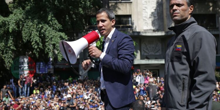 Venezuelan opposition leader and self-proclaimed acting president Juan Guaido (C) speaks to supporters next to high-profile opposition politician Leopoldo Lopez, who had been put under home arrest by Venezuelan President Nicolas Maduro's regime, and members of the Bolivarian National Guard who joined his campaign to oust Maduro, in Caracas on April 30, 2019. - Guaido -- accused by the government of attempting a coup Tuesday -- said there was "no turning back" in his attempt to oust President Nicolas Maduro from power. (Photo by Cristian HERNANDEZ / AFP)        (Photo credit should read CRISTIAN HERNANDEZ/AFP/Getty Images)