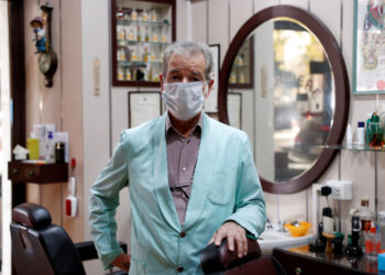 El barbero Luigi Pinzo, de 80 años, posa para una foto dos días antes de cerrar su peluquería después de 60 años debido a la menor cantidad de clientes y al miedo a la enfermedad del coronavirus (COVID-19), en Roma, Italia. 29 de octubre de 2020. REUTERS/Guglielmo Mangiapane