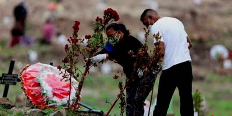 Una pareja visita la tumba de un familiar hoy, en el Parque Memorial Jardín de los Ángeles, cementerio que la Alcaldía de Tegucigalpa dispuso para enterrar a víctimas de la covid-19, en Tegucigalpa (Honduras). EFE/Gustavo Amador.