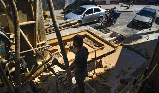 A man works during a water well drilling at the Chacao neighborhood in Caracas on October 31, 2020, amid the new coronavirus pandemic. - The drilling of wells in the Venezuelan capital gained strength during the pandemic, in view of the deficient service of drinking water. (Photo by Federico PARRA / AFP)