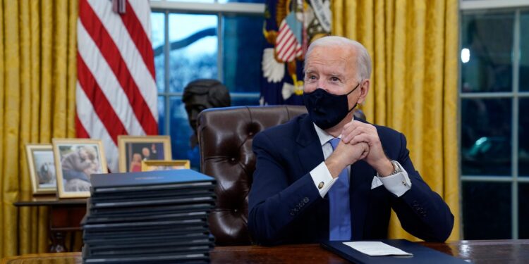 President Joe Biden waits to sign his first executive order in the Oval Office of the White House on Wednesday, Jan. 20, 2021, in Washington. (AP Photo/Evan Vucci)