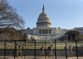 Miembros de la Guardia Nacional caminan detrás de una valla instalada frente al Congreso de Estados Unidos, un día después de que  partidarios del presidente Donald Trump ocuparon el edificio, en Washington. 7 de enero de 2021. REUTERS/Stephanie Keith