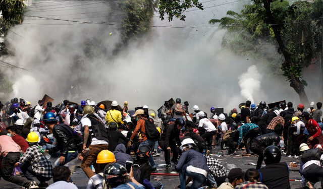 Protesters react after police fired tear gas during a demonstration against the military coup in Mandalay on March 3, 2021. (Photo by STR / AFP)