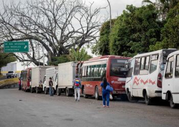 AME4731. CARACAS (VENEZUELA), 23/03/2021.- Transportistas hacen fila con sus vehículos para surtir diésel en una estación de servicio, el 22 de marzo, en Caracas (Venezuela). Con una sociedad empobrecida, golpeada y desnutrida, Venezuela es testigo de un nuevo azote para su crisis, la escasez de combustible diésel, Clave para el traslado de bienes por el país. Las largas filas de transportistas que comienzan a verse son el augurio de una nueva tormenta que puede desatarse con un resultado impredecible. EFE/ Rayner Pena R