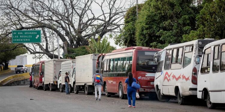 AME4731. CARACAS (VENEZUELA), 23/03/2021.- Transportistas hacen fila con sus vehículos para surtir diésel en una estación de servicio, el 22 de marzo, en Caracas (Venezuela). Con una sociedad empobrecida, golpeada y desnutrida, Venezuela es testigo de un nuevo azote para su crisis, la escasez de combustible diésel, Clave para el traslado de bienes por el país. Las largas filas de transportistas que comienzan a verse son el augurio de una nueva tormenta que puede desatarse con un resultado impredecible. EFE/ Rayner Pena R