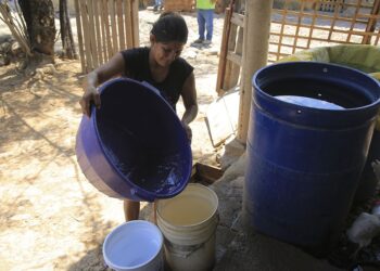 ACOMPAÑA CRÓNICA: HONDURAS AGUA - TG1013. CHOLUTECA (HONDURAS), 23/04/2018.- Fotografía del 13 de abril de 2018 de una mujer almacenando agua en envases plásticos para su uso domiciliario en el sector de Apacilagua, unos 30 kilómetros al este de Choluteca (Honduras). La ciudad de Choluteca, en el sur de Honduras, vuelve a padecer una fuerte sequía que afecta a sus 200.000 habitantes y al sector agrícola, al no poder utilizar como quisiera el agua del río Choluteca, que desde hace años esta bajo una concesión de uso privado. Durante los meses de abril y mayo, el río Choluteca se mantiene prácticamente seco, lo que impacta negativamente en las necesidades de agua de los habitantes, limita la producción agrícola y eleva los costos de actividades como la caña de azúcar que, justamente en esos meses, requiere de importantes cantidades de agua para riego. EFE/Gustavo Amador