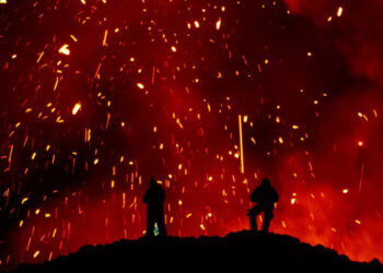 A picture taken on March 16, 2021 shows people watching Klyuchevskoy volcano eruption on Russia's far eastern Kamchatka peninsula. - The eruption of a volcano on a Russian peninsula has attracted thrill-seeking tourists risking their lives for picturesque photos, prompting concerns in recent days from local emergency responders. (Photo by MAXIM FESYUNOV / AFP)