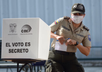 A policewoman votes at a polling station placed at the Vicente Rocafuerte university of the Tarqui parish, in Cuenca, Ecuador on April 11, 2021. - Ecuadorans elect their next president on Sunday with voters choosing between a young, socialist protege of ex-leader Rafael Correa and a veteran conservative as the oil-rich country contends with an economic crisis aggravated by the Covid-19 pandemic. (Photo by Fernando Mendez / AFP)