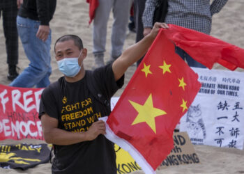 (FILES) In this file photo a member of local natives of Hong Kong shows a broken Chinese flag during a flash mob march to show solidarity with the 47 pro-democracy activists in Hong Kong who were charged for state subversion due to them organizing and taking part in a primary election, in Santa Monica, California on March 7, 2021. - The United States reaffirmed on March 31, 2021 that Hong Kong has lost its autonomy from China as it vowed to pressure Beijing for dismantling the city's special status.A day after China approved a radical overhaul of Hong Kong's political system, Secretary of State Antony Blinken in a required report to Congress found that the financial hub "does not warrant different treatment under US law" from the mainland. (Photo by RINGO CHIU / AFP)