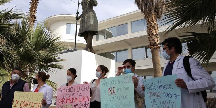 Un grupo de médicos protestaN afuera del Hospital General para exigir la aplicación de la vacuna contra la covid-19, en Ciudad Juárez (México). EFE/ Luis Torres