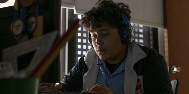 Luciano Rodriguez, 13, listens to an online history class AT his home in La Boyera neighborhood in Baruta, Caracas, on October 7, 2020, amid the new coronavirus pandemic. - With students that have to catch internet in the streets and teachers who earn 2,5 US dollars a month, classes start up again in Venezuela. (Photo by Camille Rodriguez / AFP)