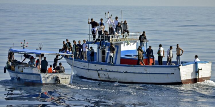 Tunisian Croissant Sportif Chebbien (CSC) football fans, who have threatened for weeks to emigrate to Italy in protest over sanctions against their club, board fishing boats on November 12, 2020 in the Mediterranean port of Chebba, accompanied by the Tunisian coast guard. (Photo by ALI ABBES / AFP)