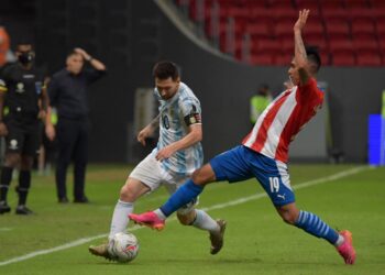 Argentina's Lionel Messi (L) and Paraguay's Santiago Arzamendia vie for the ball during their Conmebol Copa America 2021 football tournament group phase match at the Mane Garrincha Stadium in Brasilia on June 21, 2021. (Photo by NELSON ALMEIDA / AFP)