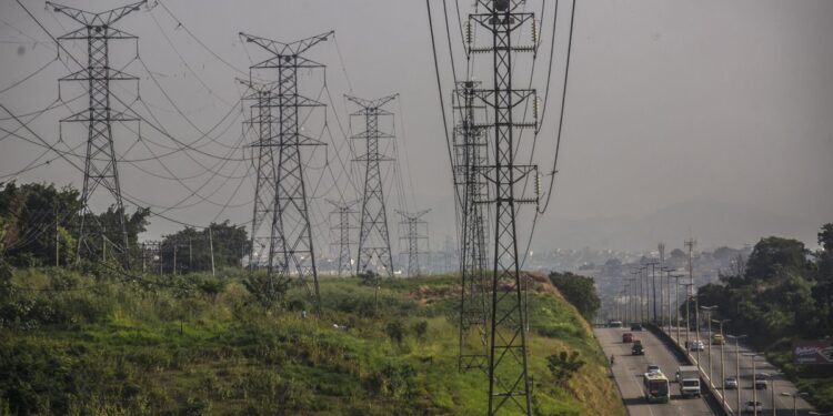 Vehicles travel along a road next to Centrais Eletricas Brasileiras SA (Eletrobras) transmission towers in Rio de Janeiro, Brazil, on Friday, May 21, 2021.  Brazil’s lower house approved the main text of a bill that paves the way for the privatization of state utility Eletrobras. Photographer: Dado Galdieri/Bloomberg