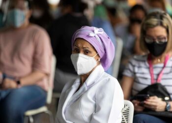 AME2413. CARACAS (VENEZUELA), 01/06/2021.- Una trabajadora de la salud espera su turno para ser vacunada contra la covid-19, el 28 de mayo de 2021, en el Concejo Municipal de Baruta, en Caracas. Venezuela continúa este martes en una particular contrarreloj para cumplir con la meta de vacunar al 70 % de la población, un proceso que, aparentemente, tomó relativa fuerza el fin de semana bajo un sistema segregado de "privilegios" a través del carnet de la patria impulsado por el chavismo. EFE/Rayner Peña R.