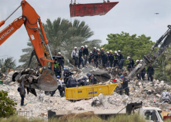 SURFSIDE, FLORIDA - JULY 05: After a brief stoppage to demolish the standing remains, Search and Rescue personnel continue working in the rubble pile of the partially collapsed 12-story Champlain Towers South condo on July 5, 2021 in Surfside, Florida. The decision by officials to bring the rest of the building down was brought on by the approach of Tropical Storm Elsa and fears that the structure might come down in an uncontrolled fashion. Over one hundred people are missing as the search-and-rescue effort continues.   Joe Raedle/Getty Images/AFP (Photo by JOE RAEDLE / GETTY IMAGES NORTH AMERICA / Getty Images via AFP)