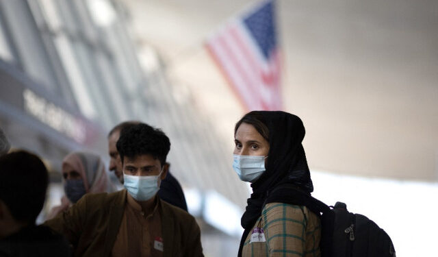 DULLES, VIRGINIA - AUGUST 26: Refugees evacuated from Kabul Afghanistan wait to board a bus at Dulles International Airport that will take them to a refugee processing center on August 26, 2021 in Dulles, Virginia. With a deadline of August 31 looming, and the detonation of a bomb earlier today near the Kabul airport, pressure to evacuate allied support personnel and Americans is rapidly increasing.   Win McNamee/Getty Images/AFP (Photo by WIN MCNAMEE / GETTY IMAGES NORTH AMERICA / Getty Images via AFP)