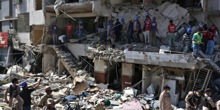 Pakistan's troops and rescue workers look for survivors amid the rubble of a damaged building following the explosion, in Karachi, Pakistan, Wednesday, Oct. 21, 2020. Police and rescuers say a powerful blast has ripped through a multistory building in Pakistan’s southern port city of Karachi. (AP Photo/Fareed Khan)