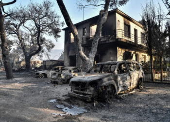 This photograph taken on August 4, 2021 shows burned cars at a burned horse riding facility in Varybombi, a suburb north of Athens, as fires broke out at the foot of Mount Parnes, 30 kilometres north of Athens. - Greek firefighters said in a statement that they hope to bring a forest fire blazing near Athens under control "in the coming hours". More than 500 firefighters, a dozen water-bombing planes and five helicopters have been battling the blazes outside the capital since August 3 afternoon. (Photo by LOUISA GOULIAMAKI / AFP)