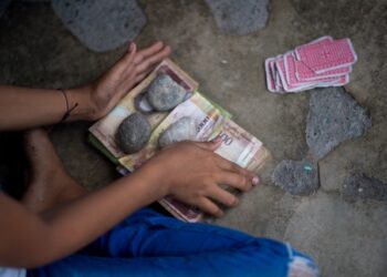 Vista de un montón de basura con billetes de bolívares venezolanos sin usar en una calle de la ciudad de Puerto Concha, estado Zulia, Venezuela, el 8 de septiembre de 2021. – Niños juegan con billetes de bolívares en una ciudad venezolana donde el peso colombiano representa la mayoría de las transacciones, seguido por el dólar estadounidense. Para muchos en Puerto Concha, Zulia (oeste), el bolívar es historia. (Foto de Federico PARRA / AFP)