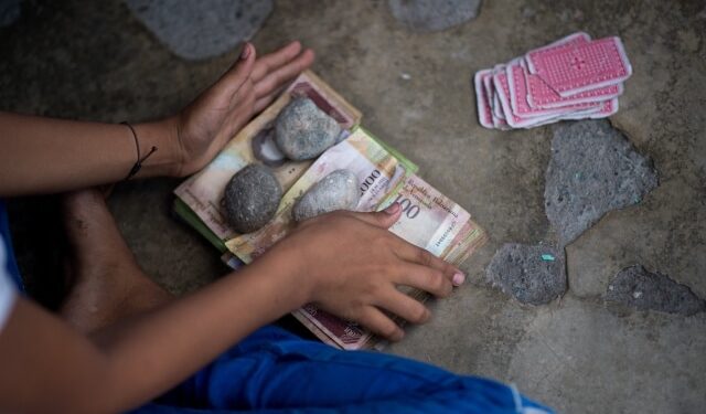 Vista de un montón de basura con billetes de bolívares venezolanos sin usar en una calle de la ciudad de Puerto Concha, estado Zulia, Venezuela, el 8 de septiembre de 2021. – Niños juegan con billetes de bolívares en una ciudad venezolana donde el peso colombiano representa la mayoría de las transacciones, seguido por el dólar estadounidense. Para muchos en Puerto Concha, Zulia (oeste), el bolívar es historia. (Foto de Federico PARRA / AFP)