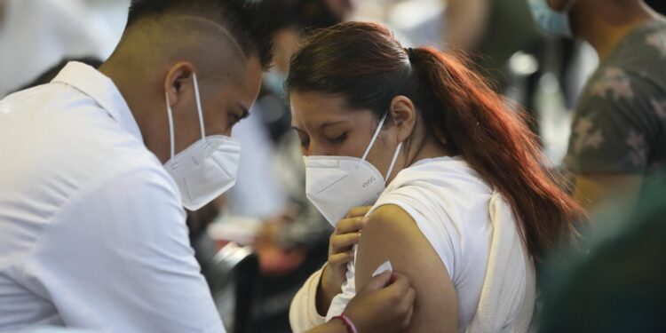 Fotografía de archivo del 24 de agosto de 2021 que muestra a un vacunador tras aplicar una dosis de la vacuna contra la covid-19 a una mujer, en Ciudad de México. La desigualdad sigue marcando el proceso de inmunización contra la covid-19 en América, donde organismos internacionales urgen por fortalecer la producción local de dosis en medio de la nueva ola de la pandemia y el debate creciente sobre la exigencia de un certificado de vacunación. EFE/ Sáshenka Gutiérrez