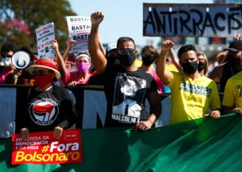 People raise their fists during a protest against Brazilian President Jair Bolsonaro and racism in Brasilia, Brazil, on June 21, 2020, amid the COVID-19 coronavirus pandemic. - The novel coronavirus has killed at least 464,423 people worldwide since the outbreak began in China last December, being Brazil Latin America's worsthit country with 49,976 deaths from 1,067,579 cases. (Photo by Sergio LIMA / AFP)