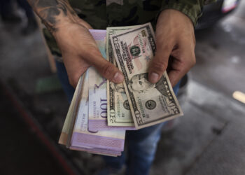 A man tries to pay for gasoline with a 20$ in Caracas, Venezuela, on June 5, 2019.