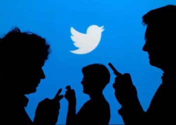 FILE PHOTO: People holding mobile phones are silhouetted against a backdrop projected with the Twitter logo in this illustration picture taken September 27, 2013. REUTERS/Kacper Pempel/Illustration/File Photo/File Photo