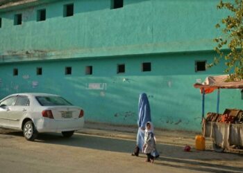 Una mujer afgana vestida con burka y una niña caminan por una calle en Qala-e-Naw, en la provincia de Badghis el 16 de octubre de 2021 Hoshang Hashimi AFP