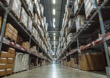 Large warehouse logistic or distribution center. Interior of warehouse with rows of shelves with big boxes