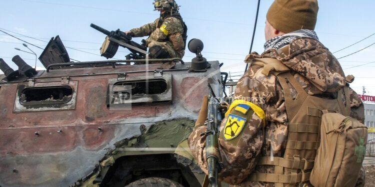 Soldados ucranianos inspeccionan el domingo 27 de febrero de 2022 un vehículo militar dañado tras combates en Járkiv, Ucrania. (AP Foto/Marienko Andrew)