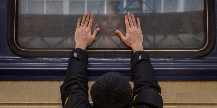 Aleksander, de 41 años, aprieta las palmas de las manos contra la ventanilla mientras se despide de su hija Anna, de 5 años, en un tren hacia Lviv en la estación de Kiev, Ucrania, el viernes 4 de marzo de 2022.