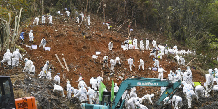 Fotografía proporcionada por la agencia de noticias Xinhua de trabajadores en una operación de búsqueda y rescate en el sitio en donde cayó un avión el lunes en el condado Tengxian, en la región autónoma Guangxi Zhuang de China, el viernes 25 de marzo de 2022. (Lu Boan/Xinhua vía AP)