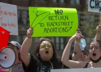 Pro-choice counter-protesters hold signs on the sidelines of the pro-life National March for Life in Ottawa, Ontario, on May 12, 2022. - The protest comes amid a political firestorm in the United States ignited by a leaked draft opinion that showed the Supreme Court's conservative majority preparing to overturn Roe v. Wade, a landmark 1973 ruling guaranteeing abortion access nationwide. (Photo by Lars Hagberg / AFP)