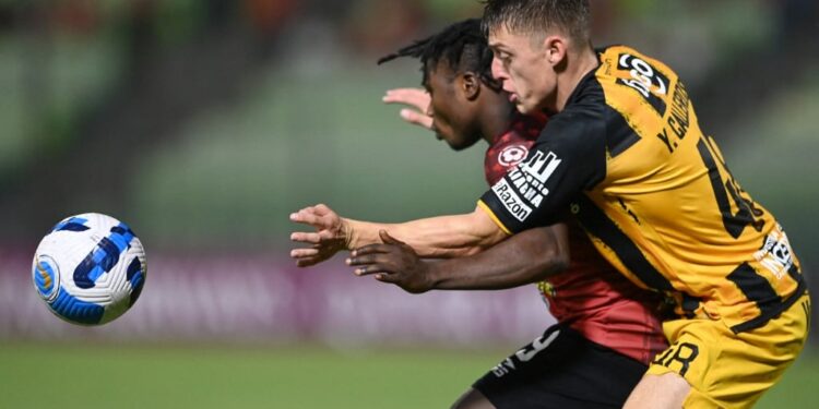 Venezuela's Caracas Samson Akinyoola (L) and Bolivia's The Strongest Uruguayan Yvo Calleros vie for the ball during the Copa Libertadores group stage football match, at the UCV Olympic stadium in Caracas, on May 17, 2022. (Photo by YURI CORTEZ / AFP)