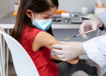 Little girl receiving coronavirus vaccine at doctor's office